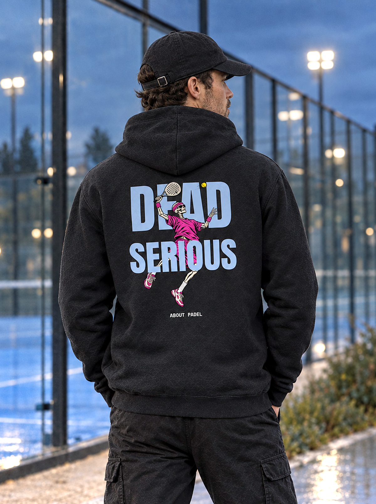 Mann von hinten im schwarzen Hoodie mit Dead-Serious-Rückenprint am Padelcourt